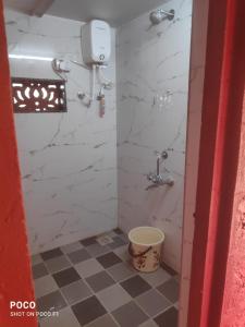 a bathroom with a shower with a bucket in it at Om Gajanan Farms in Nerur