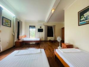 Großes Zimmer mit 2 Betten und einem TV. in der Unterkunft Homestay Xuandung in Ninh Bình