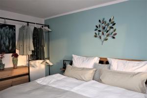 1 dormitorio con 1 cama con sábanas y almohadas blancas en Apartment mit Terassee & Aussicht auf See und Berge en Lochau