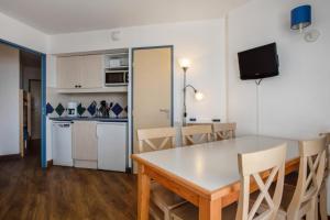 a dining room and kitchen with a table and chairs at Résidence Les Océanes - maeva Home - Appartement 2 pièces 6 personnes Confort - vue mer MAE-6393 in Pornichet +12 photos