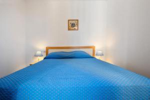 a blue bed in a bedroom with two lamps at Résidence Les Océanes - maeva Home - Appartement 2 pièces 6 personnes Confort - vue mer MAE-6393 in Pornichet