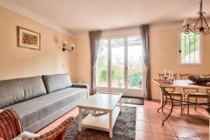 ein Wohnzimmer mit einem Sofa und einem Tisch in der Unterkunft Les maisons et villas de Pont Royal en Provence - maeva Home - Maison cosy et fe in Mallemort