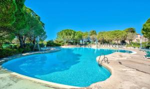 einen Pool mit blauem Wasser in einem Resort in der Unterkunft Les maisons et villas de Pont Royal en Provence - maeva Home - Maison cosy et fe in Mallemort