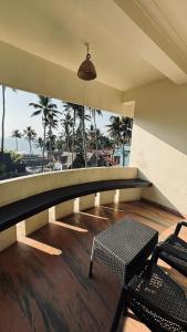 a balcony with a table and chairs and a view of the ocean at hello beach view resorts in Varkala