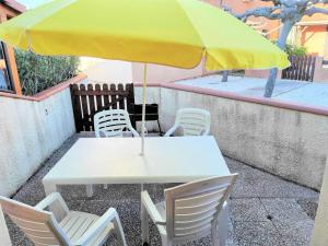a white table and chairs with a yellow umbrella at Résidence Maisons De La Plage - VILLA T2 MEZZANINE 6 couchages PORT LEUCATE. Réf: 1MPL_95D MAE-6034 in Port Leucate +7 photos