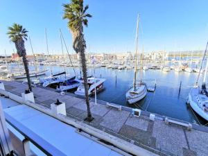 a marina with boats in the water with palm trees at Résidence LES TERRASSES DU PORT - 2 Pièces pour 4 Personnes 04 in Port Leucate