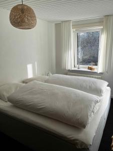 a bedroom with two white beds and a window at Cozy Holiday Apartment In Allinge in Allinge