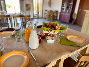 una mesa con un tazón de comida y una botella de leche en Mama Adama - Alpaca Farm & Hotel, en Grândola