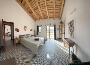 1 dormitorio con 1 cama grande en una habitación en Mama Adama - Alpaca Farm & Hotel, en Grândola