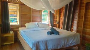 een slaapkamer met een bed met een blauwe hoed erop bij Relax House in Ko Phayam