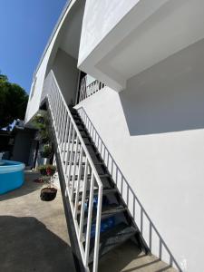 a stairway leading up to a house with white stairs at Habitación cerca del aeropuerto #1 