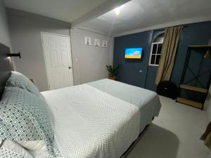 - une chambre avec un lit blanc et un mur bleu dans l'établissement Habitación cerca del aeropuerto #1, 