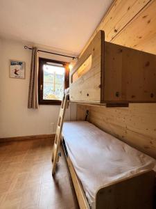 Ce lit superposé se trouve dans une petite chambre avec une échelle. dans l'établissement Les Chalets Des Evettes - 2 Pièces pour 4 Personnes 94, à Notre-Dame-de-Bellecombe