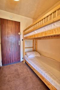 a bedroom with two bunk beds and a door at Résidence Le Chambet - Studio calme avec jardin MAE-3354 in Notre-Dame-de-Bellecombe