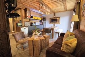 uma sala de estar com um sofá e uma cozinha em Chalet La Chalee - 5 Pièces pour 8 Personnes 64 em Notre-Dame-de-Bellecombe