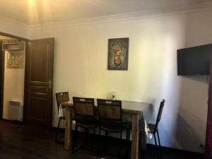 瓦盧瓦爾的住宿－Résidence Les Valmonts - 2 Pièces pour 5 Personnes 94，餐桌、椅子和墙上的绘画