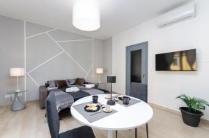 a living room with a bed and a white table at VivimiHome - Vivi i Navigli Elegante e centrale in Milan