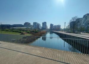 a body of water with a fence next to a river at Duplex luxury à 15’ JOP stade de France in Saint-Ouen