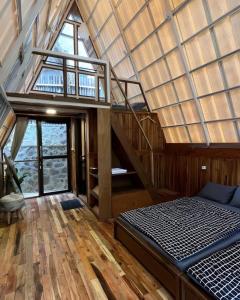 Palayangan的住宿－Luxury cabin and cafe hutan pinus rahong，一间卧室设有楼梯,卧室内设有一张床