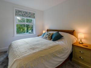 een slaapkamer met een bed en een raam bij 5 Bed in Bude 79454 in Milton Damerel