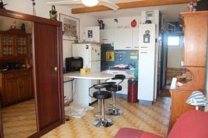 een keuken met een tafel en 2 barkrukken bij Résidence KARUKERA - Studio pour 3 Personnes 24 in Port Leucate