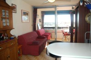 een woonkamer met een rode bank en een tafel bij Résidence KARUKERA - Studio pour 3 Personnes 24 in Port Leucate