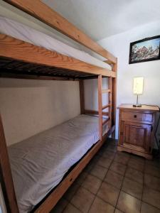 1 dormitorio con 2 literas y mesita de noche en Résidence GRANDE BLEUE - Maisons & Villas pour 6 Personnes 294, en Port Leucate