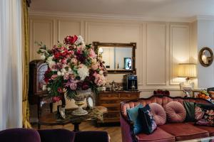a living room with a couch and a vase of flowers at Ateneea Luxury Rooms in Cluj-Napoca