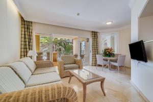 a living room with a couch and a tv at Palm Oasis Maspalomas in Maspalomas