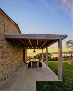 a patio with a table and a stone wall at Villa Polvese Luxury Estate in Magione