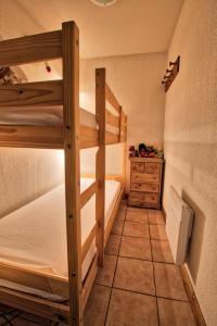 a small room with two bunk beds and a dresser at Résidence Les Oursons - 2 Pièces pour 4 Personnes 354 in Notre-Dame-de-Bellecombe