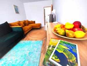a living room with a couch and a bowl of fruit at Komfortowy Apartament Narie in Kretowiny