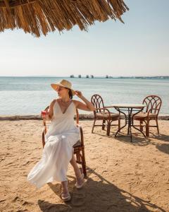 Eine Frau auf einem Stuhl am Strand in der Unterkunft Siva Grand Beach in Hurghada