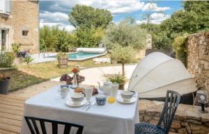 a table with a white table cloth on a patio at Chambre d'hôtes de la Savonnerie in Vénéjan