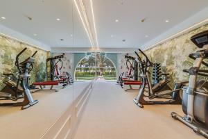 einen Fitnessraum mit Laufbändern und Crosstrainern in der Unterkunft Palm Oasis Maspalomas in Maspalomas