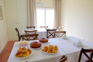 a table with several plates of pastries on it at Quinta da Caldeireira in Rosmaninhal