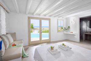 a white living room with a couch and a pool at Mykonos Dream Villas in Elia