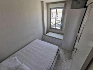 Cette petite chambre comprend un lit et une fenêtre. dans l'établissement Résidence TERRASSES DE LA MEDITERRANEE 1 - 2 Pièces pour 4 Personnes 94, à Port-Leucate