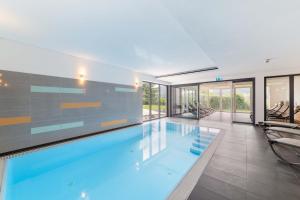 a swimming pool in a house with glass walls at Sontheims Naturhotel & Spa in Maierhöfen