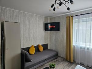 een woonkamer met een bank met gele kussens bij Apartamenty Premium Biznes Rumia in Rumia