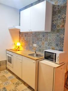 una pequeña cocina con fregadero y microondas en B Reform Netflix Parking según disponibilidad, en Sevilla