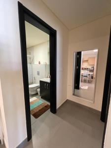 uma casa de banho com um espelho, um lavatório e um WC. em Apartment F14 - Samarah Resort em Sowayma