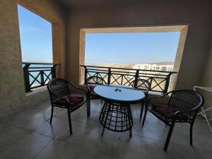 Apartment F14 - Samarah Resort في السويمة: طاولة وكراسي على شرفة مطلة