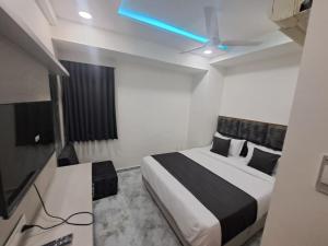 a bedroom with a bed and a ceiling fan at HOTEL AKASH in Ahmedabad