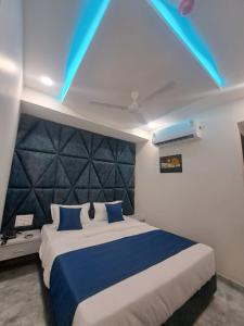 ein Schlafzimmer mit einem großen Bett mit blauen Lichtern in der Unterkunft HOTEL AKASH in Ahmedabad