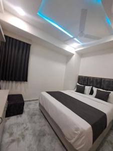 1 dormitorio con 1 cama grande y techo azul en HOTEL AKASH en Ahmedabad