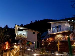 ein Gebäude mit Lichtern in der Nacht davor in der Unterkunft The Rare Ones - Resorts, Cafe & Game Zone in Mukteswar