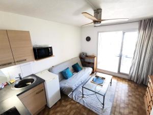 uma cozinha com um sofá e um lavatório num quarto em Résidence LES NEFS DES SABLES - Studio pour 5 Personnes 924 em Port Leucate