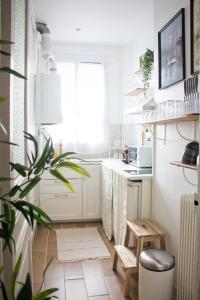 una cocina con armarios blancos y una maceta en Superbe Appartement Parisien, en Villeneuve-Saint-Georges