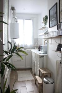 una cocina con armarios blancos y una maceta en Superbe Appartement Parisien, en Villeneuve-Saint-Georges